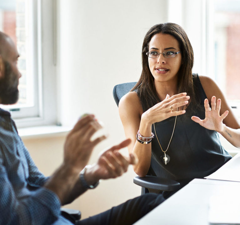 Woman and man talking in modern office.